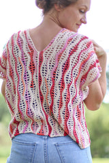 Back view of crochet top showing sideways construction and back seam. The top is made in a variegated yarn in shades of cream, pinks, and oranges.  thumbnail
