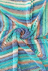 Top down view of crochet blanket laid flat and gathered in a swirl at the center.  thumbnail