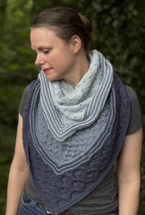 Woman standing in a forest wearing a three color knit shawl, wrapped like a bandana with the point in front.  thumbnail