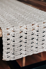Close up of end of table runner draped over table, showing lacy pattern.  thumbnail