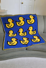 Crochet afghan lays on couch indoors.  thumbnail