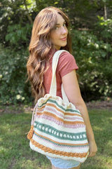 Side back view of woman wearing crochet tote on her shoulder.  thumbnail