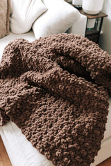 Chocolate brown afghan laid on end of chaise couch, showing velvety texture of chenille yarn.  thumbnail
