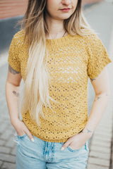 Cropped close up of woman wearing crochet lace top, with ribbed hems on body, arms, and neck opening.  thumbnail