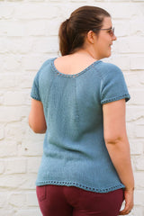 Back view of knit top. There are radiating lines of increases from the neckline and eyelet edge on neck, sleeves, and lower hem.  thumbnail