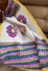 Crochet blanket draped over arm of stuffed armchair.  thumbnail