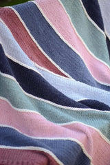 Close up of striped knit blanket with embellished cream stripes between each color block.  thumbnail