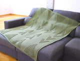Crochet blanket is laid out flat on grey couch.  thumbnail