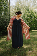 Front view of woman in a long dark dress wearing a crochet cardigan.  thumbnail