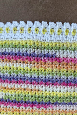 Extreme close up of blanket border, showing mix of white and self-striping yarn, and lacy edge.  thumbnail