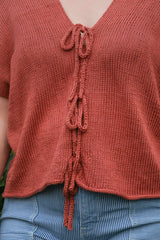 Close up of front of knit top, showing i-cord ties down the center front.  thumbnail