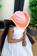 View of top of cowboy hat, showing shaped crown, lace pattern around hat bucket, braided trip, and shaped brim. The hat fades from pink to orange and back to pink.  thumbnail