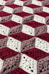 Close up of crochet afghan showing textured diamond motifs arranged in 3D cube effect.  thumbnail