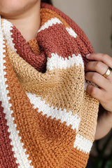 Close up of crochet shawl wrapped around person's neck, showing flat textured fabric.  thumbnail