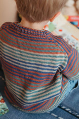 Back view of sweater on young child showing shoulder detail, ribbed collar, and dropped shoulders.  thumbnail