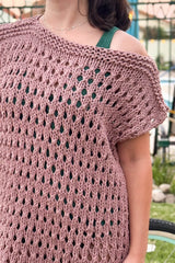 Close up of cover-up. The shoulders are knit in garter stitch and the body has a grid pattern of eyelets.  thumbnail