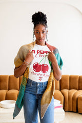 Woman wears a shawl draped over her shoulders; the points hang to just above the knee.  thumbnail