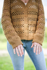 Cropped front view of cardigan showing long sleeves with solid cuffs, ribbed button band, and alternating solid and lace sections.  thumbnail