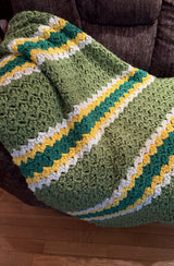 Crochet afghan draped over armchair. The afghan has a slightly textured pattern.  thumbnail