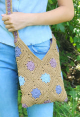Cropped front view of bag being worn crossbody. It hangs to mid-thigh at the bottom, and the opening is just below hip level.  thumbnail