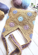 Flat lay of bag on white wooden surface, with yarn balls in the background.  thumbnail