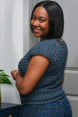Side back view of crochet top, showing keyhole opening at back neck with button closure, and short sleeve.  thumbnail