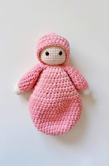 Baby doll laid flat on cream background.  thumbnail