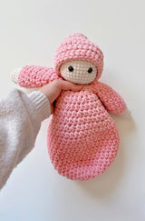 Crochet soft doll held under arms by person off camera.  thumbnail