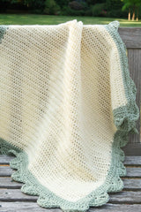 Crochet blanket draped over outdoor wooden bench.  thumbnail