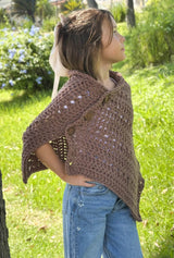 Side view of a young girl wearing a brown crochet poncho that buttons at the shoulder.  thumbnail