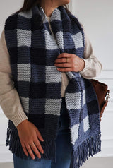 Woman wears knit gingham scarf over a cream sweater and jeans. The scarf hangs to low hip when worn draped over the shoulders.  thumbnail