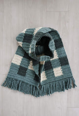 Crochet scarf laid flat on pale wooden background.  thumbnail