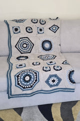 Crochet blanket draped over cream couch.  thumbnail