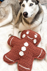 Gingerbread man pillow laying in front of husky dog.  thumbnail