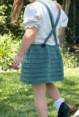Back view of knit pinafore showing open back with criss-cross straps that button at waist.  thumbnail