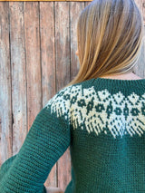 Back view of crochet sweater showing cream motif on upper yoke and textured stitch on body.  thumbnail