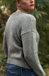 Side back view of grey sweater, showing  plain back and shoulder/sleeve seam.  thumbnail