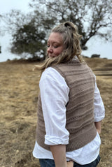 Side back view of woman wearing knit vest, showing horizontal bands of texture on back, ribbing at armholes and hem.  thumbnail