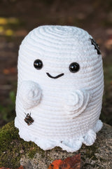 Crochet ghost stuffie, with short arms and a ruffled bottom edge. It was large black plastic eyes and an embroidered smile.  thumbnail