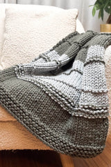 Close up of knit blanket showing garter borders and garter ridges across stockinette stitch main blanket.  thumbnail