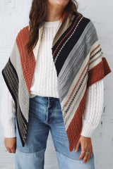 Cropped front view of large knit shawl worn draped over shoulders, over white top and jeans.  thumbnail