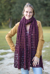 Cropped front view of woman wearing crochet stole wrapped like a scarf. It's wrapped once around her neck and hangs to mid-thigh.  thumbnail