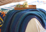 Wider view of blanket draped over corner of bed.  thumbnail