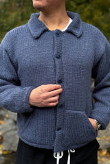 Front view of knit jacket buttoned in the front. It's made in a denim blue and has two angled front pockets.  thumbnail