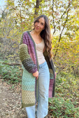 Front view of woman wearing long crochet cardigan or duster. It is open in the front, with a front band.  thumbnail