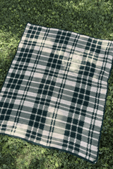 Tartan plaid crochet throw on a green lawn.  thumbnail
