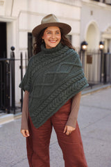 Front view of knit poncho with large diamond cable running diagonally with rope and staghorn cables on either side.  thumbnail
