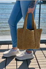 Person holding tote in front of water background thumbnail