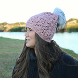 woman wearing a dusty pink crocheted beanie with a fur pom-pom thumbnail