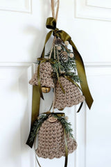 crocheted holiday bell ornament door hanger with green ribbon and evergreen sprigs thumbnail